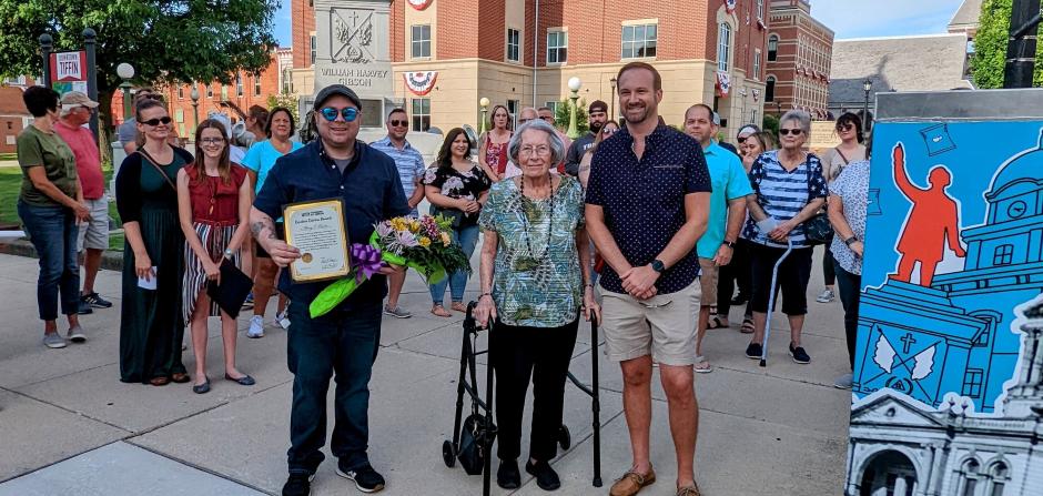 Mary Lewis (center) was presented with the Creative Citizen Award by TMAC Chairman Ryan Poignon (left) and Tiffin Mayor Aaron Montz (right) on Friday, June 10, 2022 in Downtown Tiffin.