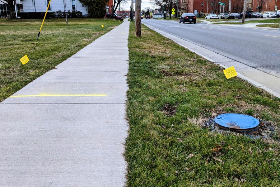 Flags are placed in the grass public right of way to mark utility lines along Miami Street in Tiffin.