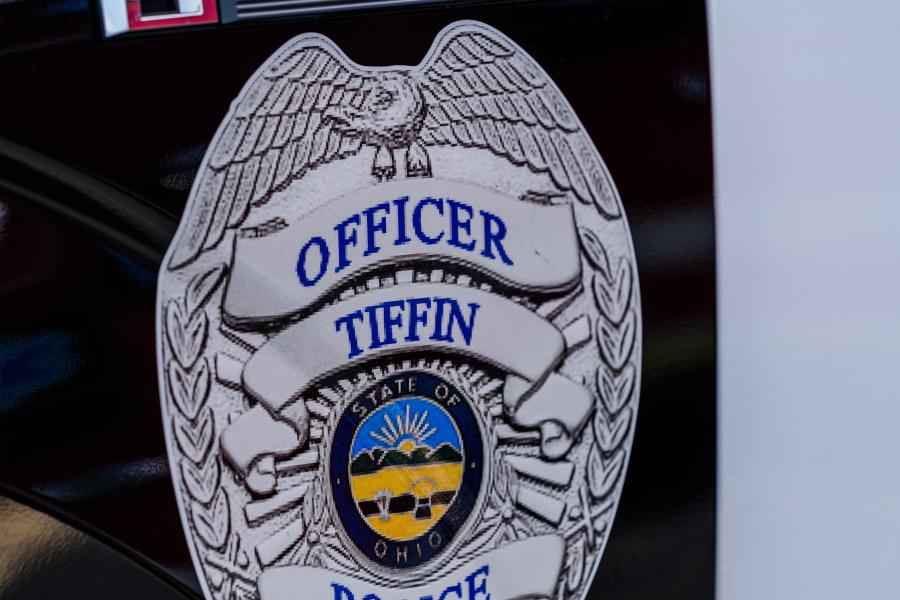 A Tiffin Police badge is shown on the side of a police vehicle